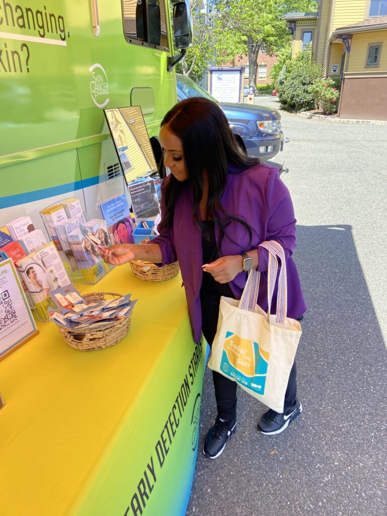 A participant in Montclair, NJ takes home a few sun protection products courtesy of EltaMD Skin Care, Jergens Natural Glow and Sun Bum.