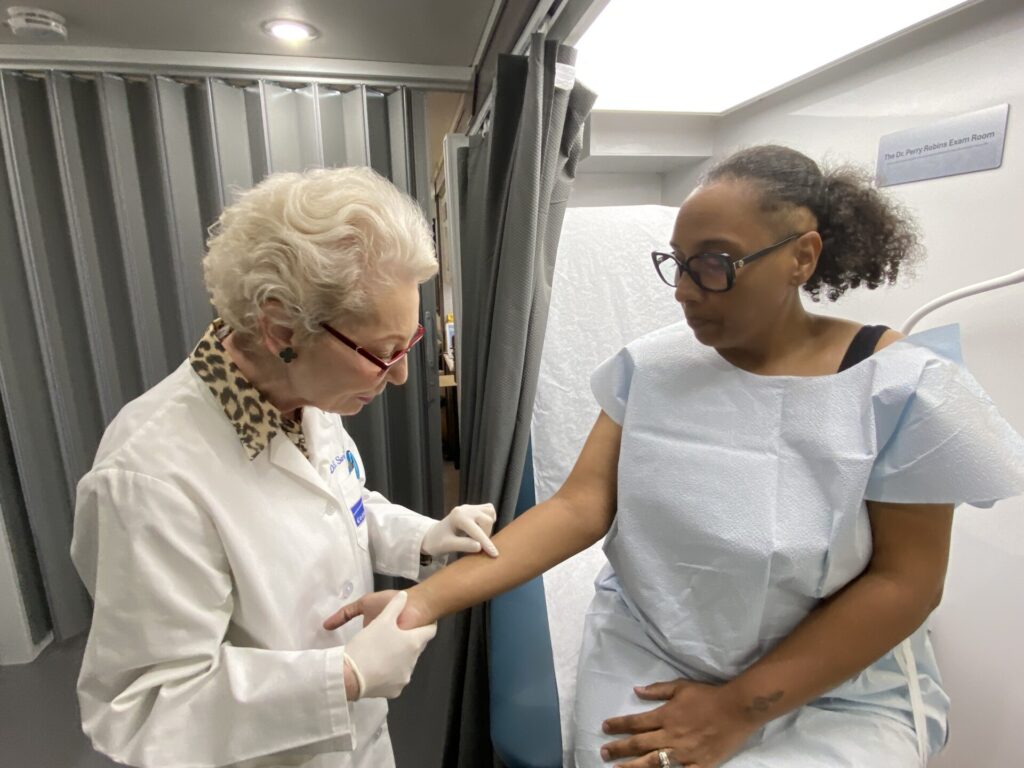 On Long Island, Deborah S. Sarnoff, MD, president of The Skin Cancer Foundation, takes a closer look at a spot on a participant's arm.