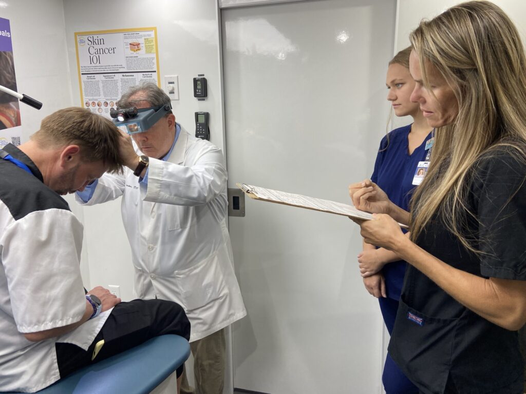 Volunteer dermatologist Jeff Stricker, MD, performing a head-to-toe skin exam in Dothan, AL.