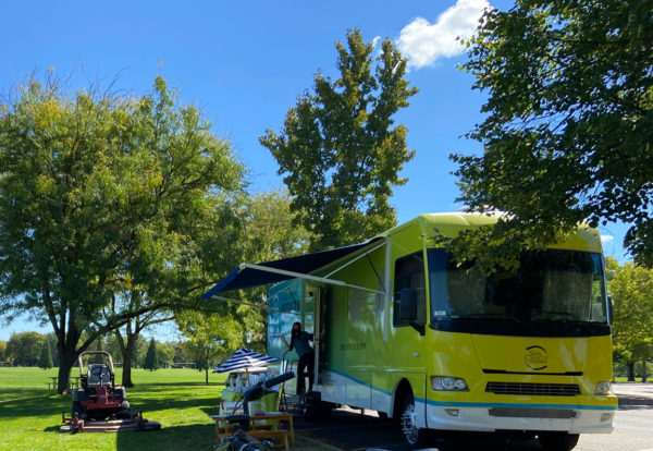 Destination Healthy Skin RV at Ann Morrison Park in Boise with lawn mower parked outside