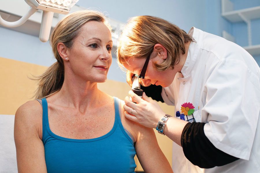 Dermatologist examining patient dermascope