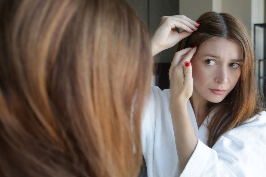 woman examining scalp