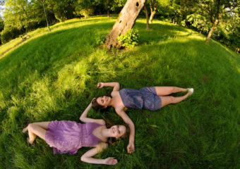 two women lying in shade on grass