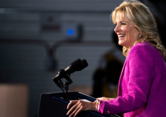 First Lady Jill Biden standing on the podium speaking in front of an audience