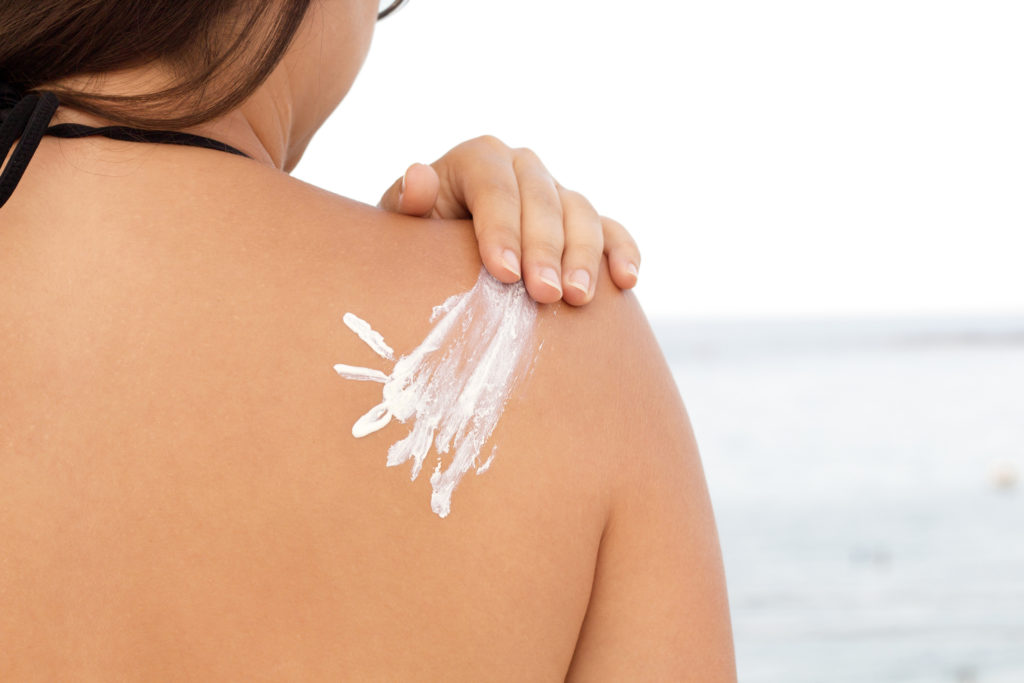 Sun cream on a woman's shoulder, horizontal