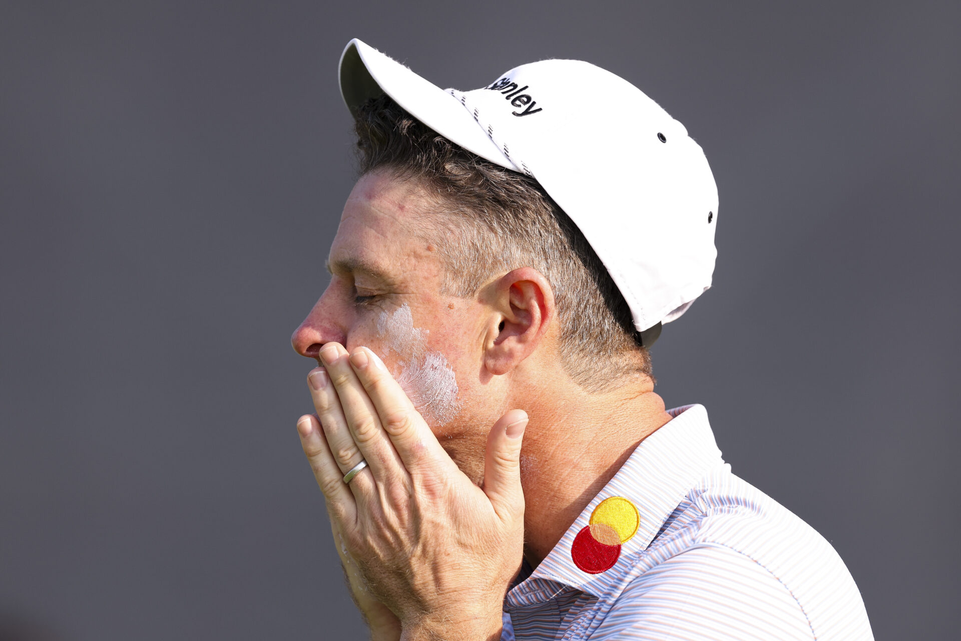 Justin Rose of England applies sunscreen