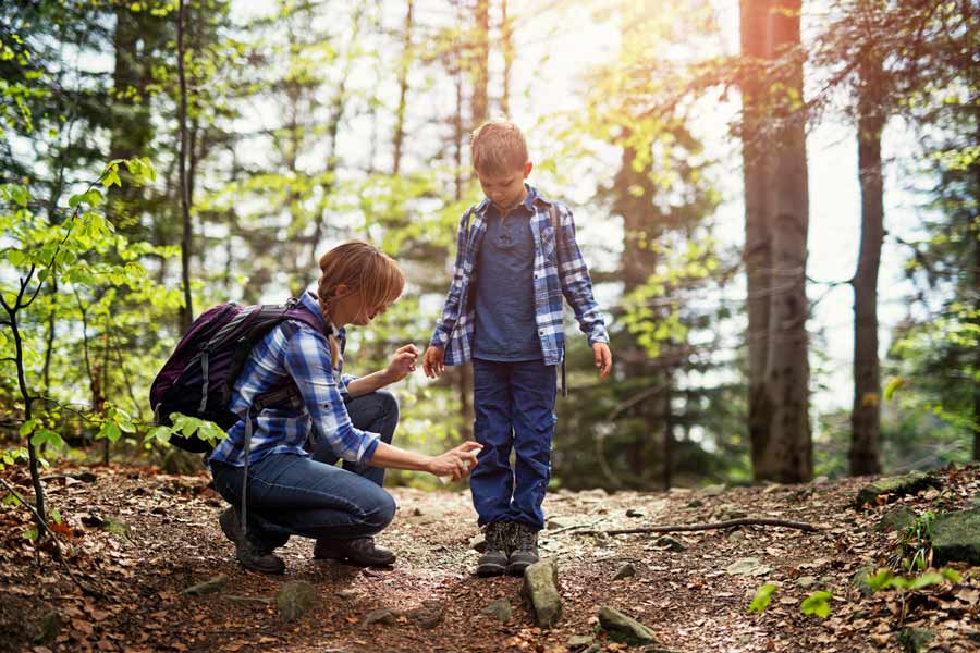 mother spraying insect repellent