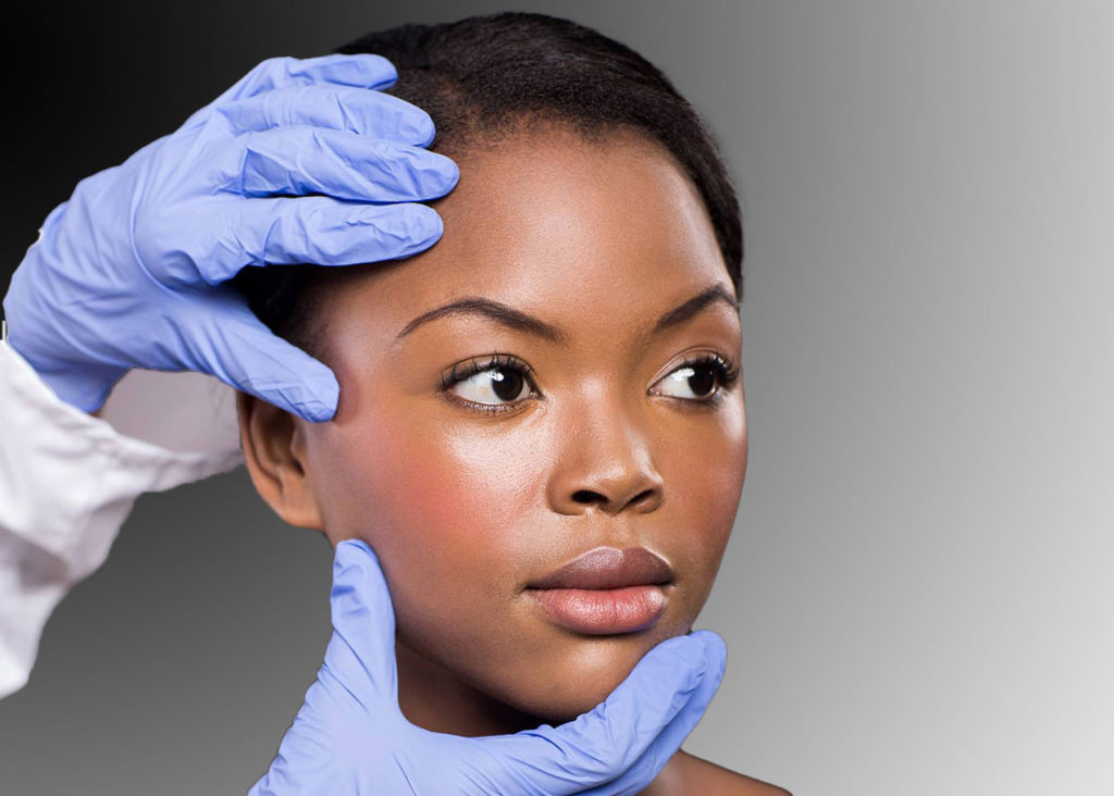 medical professional gloved hands examining skin on face