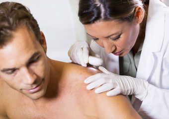Female dermatologist performing skin exam