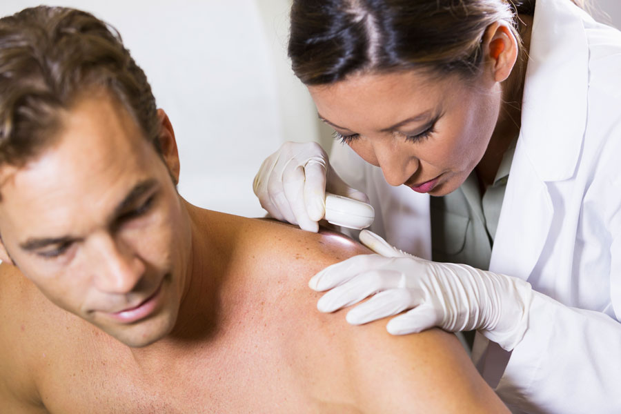 Female dermatologist performing skin exam